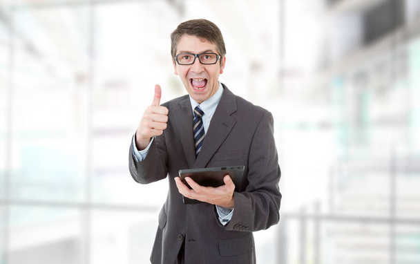 бізнесмен, використовуючи сенсорну панель планшетного ПК піднімається на великі пальці вгору, в офісі
 - Фото, зображення