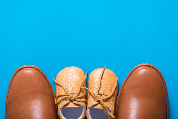 brown dad and son shoes on blue background - Foto, imagen