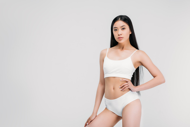 beautiful asian girl posing in white panties and bra, isolated on grey - Fotografie, Obrázek