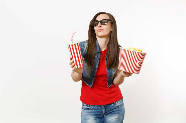 Portrait of young relaxing woman in 3d glasses with closed eyes watching movie film, holding bucket of popcorn and plastic cup of soda or cola isolated on white background. Emotions in cinema concept - Фото, зображення