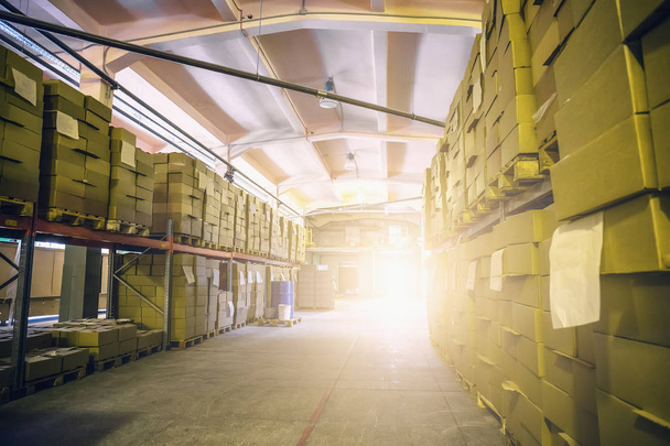 Boîtes en carton cargo dans un entrepôt de stockage logistique, intérieur de l'entrepôt à l'intérieur avec lumière du soleil
 - Photo, image