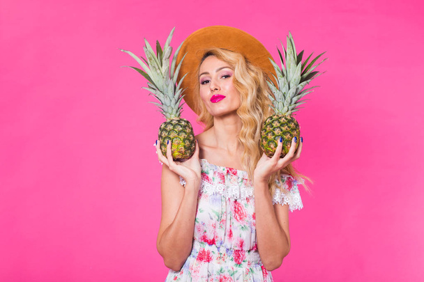 Porträt einer glücklichen Frau und Ananas auf rosa Hintergrund mit Copyspace. Sommer, Ernährung und gesunder Lebensstil - Foto, Bild