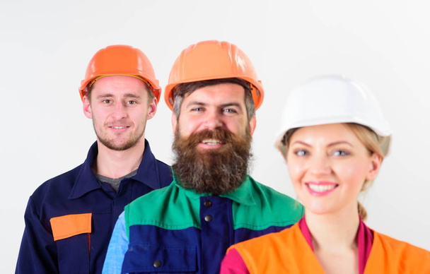 Woman and men in hard hat stand close as team. - Zdjęcie, obraz