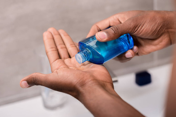 cropped shot of man pouring after shave lotion onto hand - Photo, image