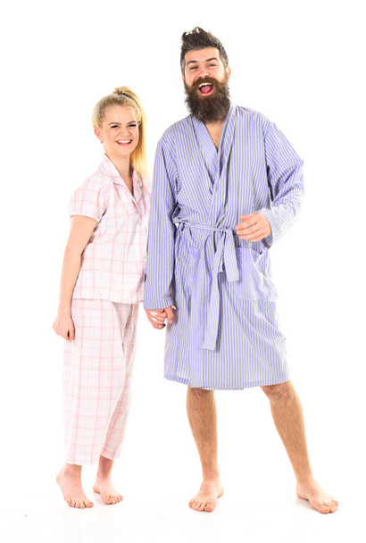 Couple, family on smiling faces in clothes for sleep looks sleepy in morning. Couple hold hands together, isolated on white background. Couple in love in pajama, bathrobe. Good morning concept - Photo, image