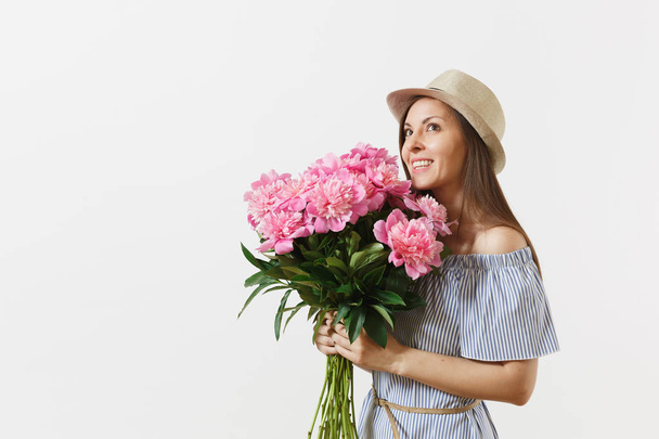 Young tender woman in blue dress, hat holding bouquet of beautiful pink peonies flowers isolated on white background. St. Valentine's Day, International Women's Day holiday concept. Advertising area - Foto, afbeelding