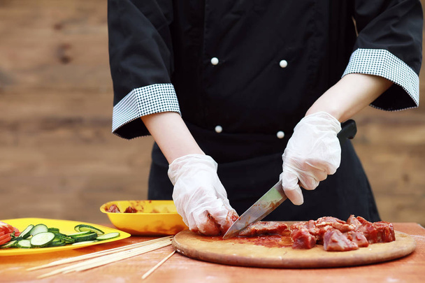 Кухар розрізає м'ясо для приготування барбекю
 - Фото, зображення