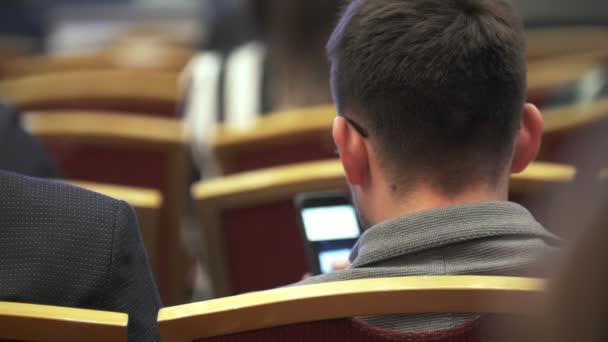 Вид ззаду молодого чоловіка, що сидить на бізнес-конференції
 - Кадри, відео