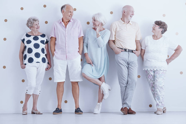 Fashionably dressed smiling senior people posing in bright studio - Foto, imagen