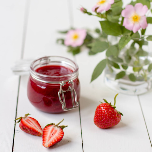 Strawberry jam in a glass jar on the table. - Photo, Image