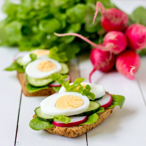 Sandwiches mit Ei, Rettich und grünem Salat. - Foto, Bild