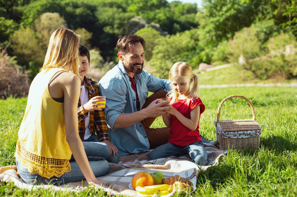 Inspired parents having picnic with their kids - Foto, Imagen