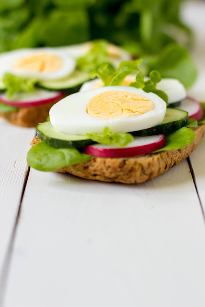 Sandwiches mit Ei, Rettich und grünem Salat. - Foto, Bild