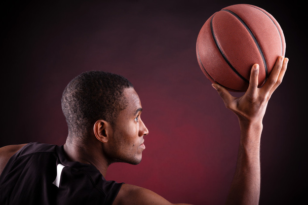 young male basketball player against black background - 写真・画像