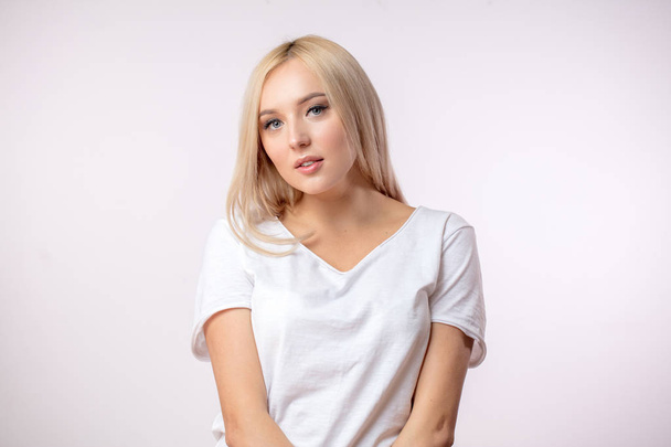 serious woman in blond wig on the white background - Foto, Bild
