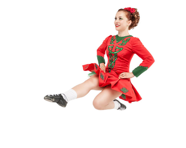 Beautiful woman in dress for Irish dance jumping isolated on white - Photo, Image