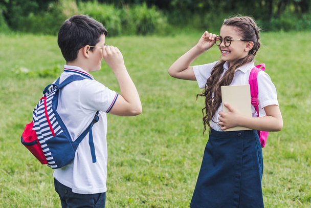 adorables écoliers avec des sacs à dos se regardant à travers des lunettes
 - Photo, image