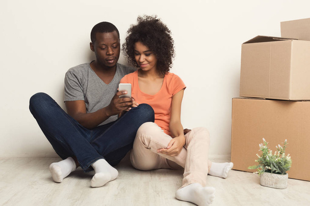 Couple noir assis sur le sol dans un nouvel appartement
 - Photo, image