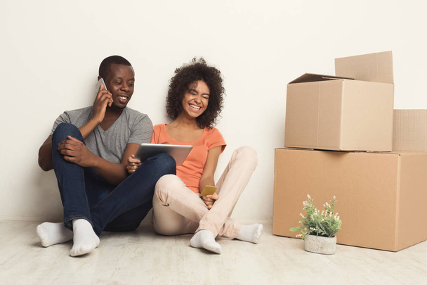 Couple noir assis sur le sol dans un nouvel appartement
 - Photo, image