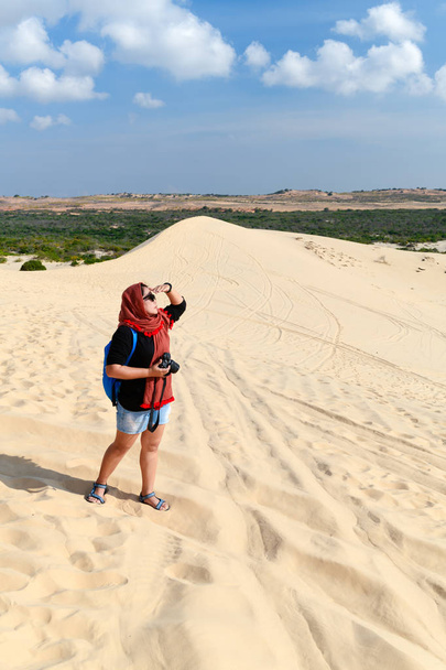 jovem viajante segurando câmera no deserto de dunas de areia branca - Mui Ne, Vietnã
 - Foto, Imagem