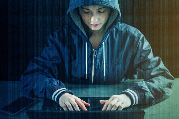 Hacker adolescente programador utiliza un ordenador portátil para hackear el sistema. Robar datos personales. Creación e infección de virus maliciosos. El concepto de delito cibernético y hackeo de dispositivos electrónicos
 - Foto, Imagen