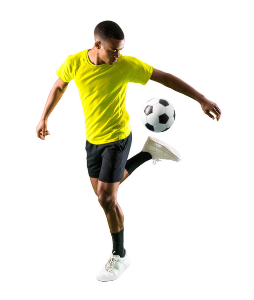 Voetbal speler man met donkere onthuid spelen op geïsoleerde witte achtergrond - Foto, afbeelding