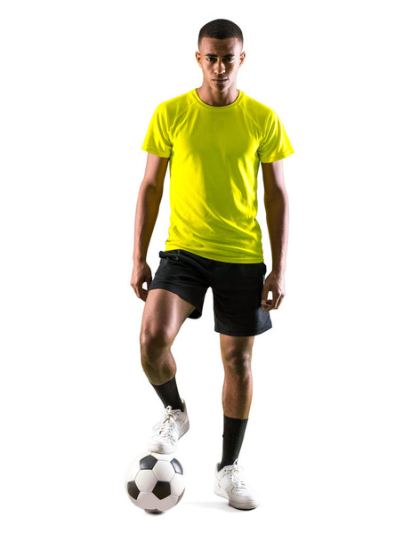 Voetbal speler man met donkere onthuid spelen op geïsoleerde witte achtergrond - Foto, afbeelding