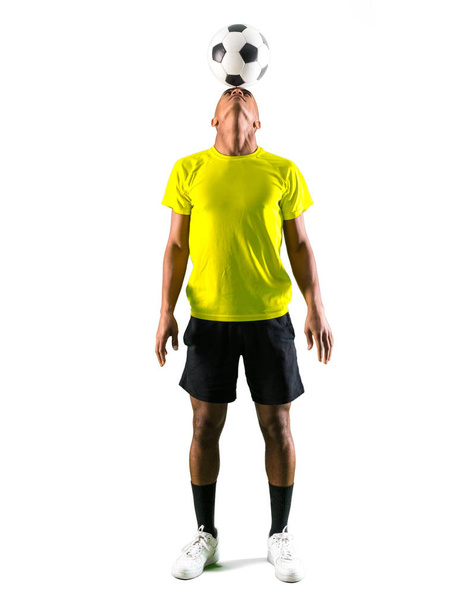 Άνθρωπος παίκτης ποδοσφαίρου με σκοτάδι εκδορά παίζουν χτυπώντας το κεφάλι στο απομονωμένο λευκό φόντο - Φωτογραφία, εικόνα