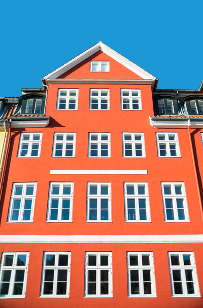 vista de ángulo bajo de hermosa casa roja tradicional con ventanas blancas en el día soleado, copenhagen
  - Foto, imagen