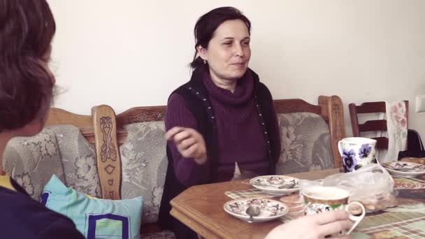 Žena hovoří se svou přítelkyní a pití čaje - Záběry, video