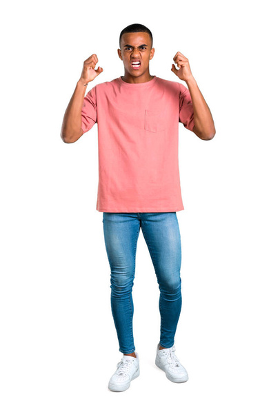 Standing young african american man annoyed angry in furious gesture. Frustrated by a bad situation on isolated white background - Фото, изображение