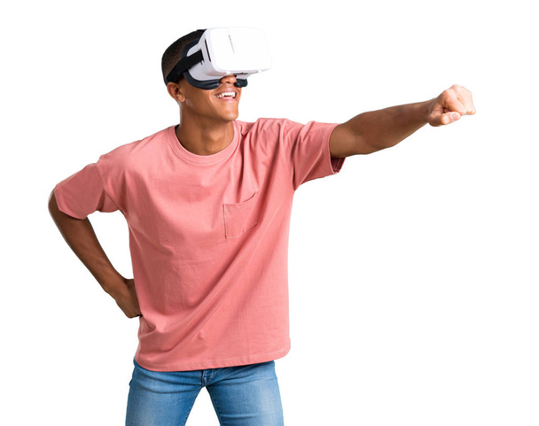 VR gözlük kullanan genç Afro-Amerikan adam. Sanal gerçeklik deneyimi izole beyaz zemin üzerine - Fotoğraf, Görsel