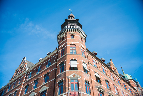 χαμηλή γωνία άποψη κτιρίου κατά φωτεινό μπλε ουρανό στην Κοπεγχάγη, Δανία - Φωτογραφία, εικόνα