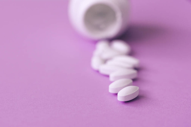 Pills spilling out of bottle on pastel blue paper background with copy space in minimal style, template for text. Concept of medical treatment, pharmacy, healthcare. - Φωτογραφία, εικόνα