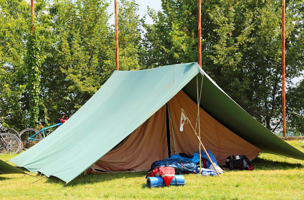 petite tente verte scout sur une pelouse avec quelques sacs à dos à l'extérieur
 - Photo, image
