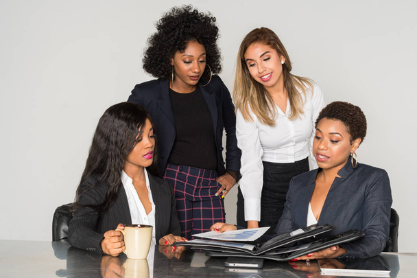 Groep van vier minderheid vrouwelijke ondernemers werken samen in het kantoor - Foto, afbeelding
