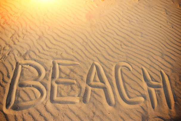 das Wort Strand steht in den Sand geschrieben. - Foto, Bild