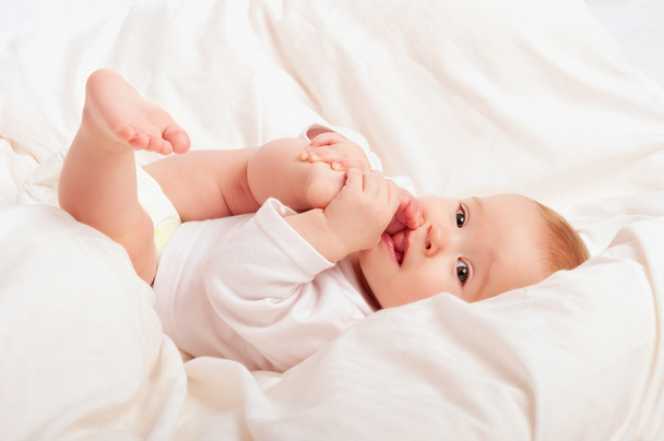 small baby sucking her finger on leg - Photo, image