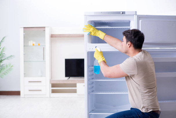 Man schoonmaken koelkast in hygiëne concept - Foto, afbeelding