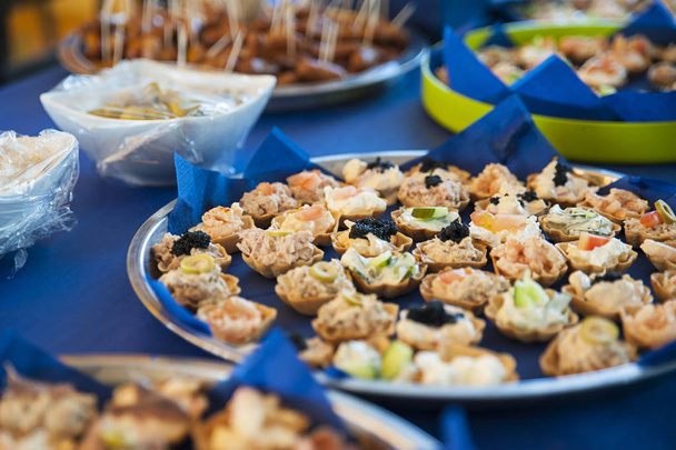 Bite sized snacks on large silver trays, appetizers or hors d'oeuvre at the buffet bar or self-service  restaurant as a starter, tapas or nibbles - Photo, Image