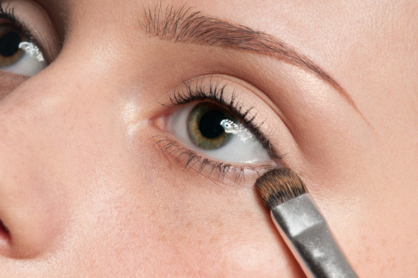 Woman applying cosmetic paint brush on eye zone - Φωτογραφία, εικόνα