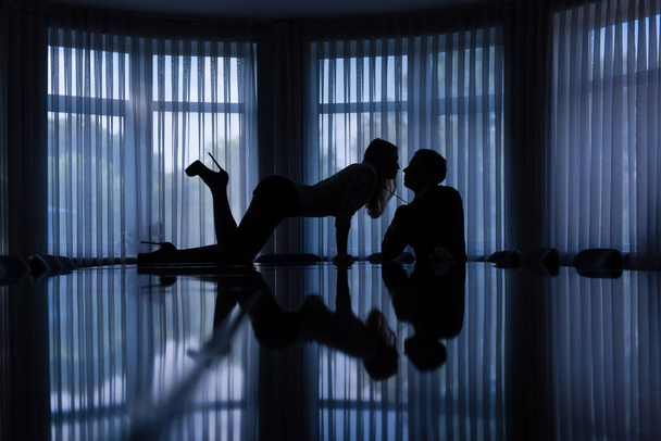 Sexy games of woman and man in dark office - Photo, image