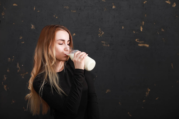 Fiatal lány ital tej, egy üveg - Fotó, kép