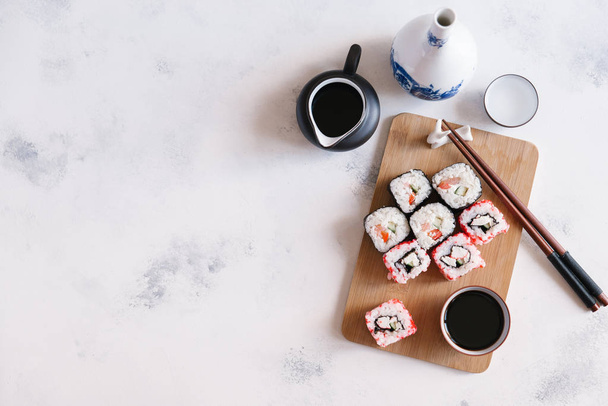 Verse heerlijke sushi geserveerd op een houten bord met sojasaus  - Foto, afbeelding