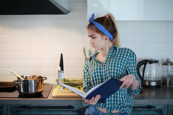 Söpö nuori tyttö keittiössä valmistaa ruokaa
 - Valokuva, kuva