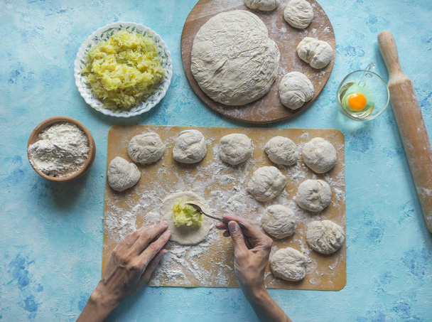 Homemade cakes of the dough in the women's hands. The process of making pies with cabbage dough by hand. - 写真・画像