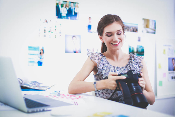 Retrato de una joven sonriente con cámara sentada en un apartamento tipo loft
 - Foto, Imagen