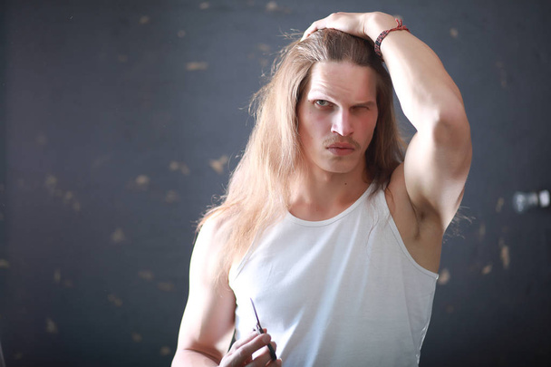 Un giovane con i capelli lunghi tagliare una serratura
 - Foto, immagini