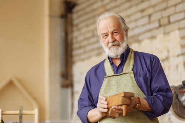 close up portrait of old male doesnt know how to work with wooden plane - 写真・画像