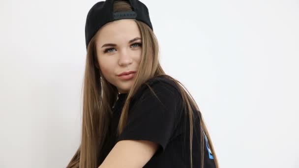 adolescente en ropa de hip hop de moda y gorra posando contra la pared blanca
 - Imágenes, Vídeo